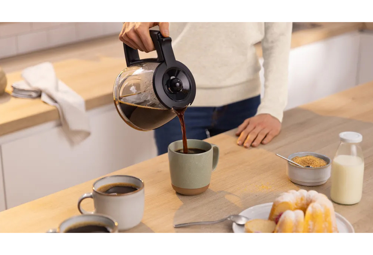 Απεικονίζεται σερβίρισμα καφέ από την κανάτα σε κούπα.